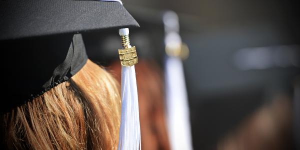 a close photo of a graduation tassle hanging from a cap
